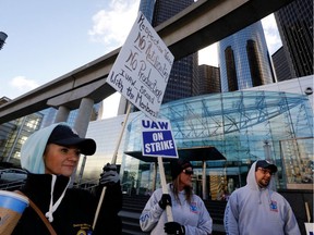 GM employee Nikki Guevara, left, pickets outside of the General Motors Renaissance Center as the UAW GM Council Meeting is being held in Detroit, Michigan, on October 17, 2019. The UAW is meeting to discuss a proposed tentative agreement with General Motors.
