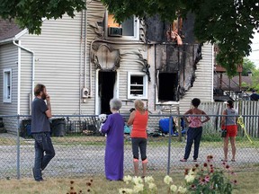Neighbourhood residents watch a house fire in the 2400 block of Arthur Road on Aug. 18, 2019.