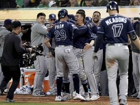 Tampa Bay Rays designated hitter Tommy Pham (29) is greeted by teammates after hitting a home run against the Oakland Athletics during the fifth inning in the 2019 American League Wild Card playoff baseball game at RingCentral Coliseum.