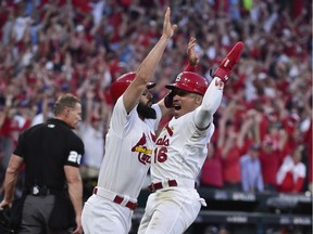 St. Louis Cardinals second baseman Kolten Wong (16) celebrates with third baseman Matt Carpenter (13) after scoring on an RBI sacrifice fly hit by catcher Yadier Molina in the 10th inning to defeat the Atlanta Braves in game four of the 2019 NLDS playoff baseball series at Busch Stadium on Oct. 7, 2019.