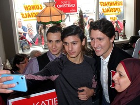 Members of the first Syrian family sponsored by the community to come to Chatham-Kent, Hamid Alhajjeh, 19, left, his brother Mulham Allajjeh, 18, and their mother Noura Alchreifi, take a selfie with Prime Minister Justin Trudeau during his stop in Tilbury, Ont. on Monday to support the campaign of Chatham-Kent-Leamington Liberal candidate Katie Omstead. (Ellwood Shreve/Chatham Daily News)