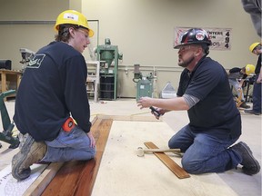 Local students participated in the High School Construction Day event at the Carpenters Union Local 494 training facility in Tecumseh on Wednesday, October 30, 2019. Students gained hands on experience with various construction trade techniques. Eric Wright, left, gets hard wood flooring installation tips from Brandon Fitch, from local 494.