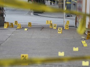 Evidence markers cover the sidewalk in front of the Pizza Pizza location at 294 Ouellette Ave. after Jason Pantlitz-Solomon was shot dead on Aug. 27, 2018.