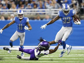 Detroit Lions running back Kerryon Johnson runs the ball against Minnesota Vikings defensive back Anthony Harris during the first quarter at Ford Field.