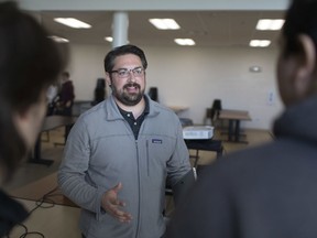 Kyle Paul, from Google's developer relations team, speaks with Grade 12 students Caiden Jones, left, and Yusuf Naebkhil after he gave a presentation to students from Tecumseh Vista Academy's e-STEAM program in the school's cafeteria on Friday, Oct. 4, 2019. The school and WEtech Alliance hosted the Industry on Campus event.