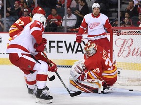 The puck slips by Calgary Flames goalie David Rittich from a shot by the Detroit Red Wings in the second period at Scotiabank Saddledome.