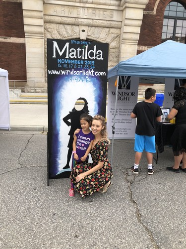 Megan Whalen, who plays Miss Honey, is shown posing next to a Matilda the Musical fan next to a cardboard cutout.