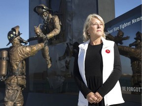 Jane Sequin, wife of late firefighter Raymond Sequin, stands next to the newly unveiled Windsor Firefighters Memorial at the waterfront in downtown Windsor, Monday, October 28, 2019.  Raymond Seguin was one of several that started the memorial project 22 years ago.