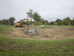 An excavator sits parked next to a small pond in Lakewood Park, off of Hayes Avenue, that's recently been cleared of vegetation surrounding the pond, Wednesday, Sept. 2, 2019.