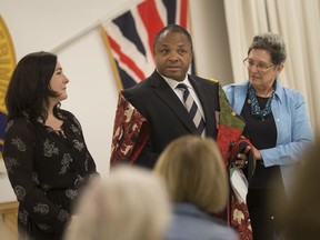 Mike Akpata, who served in Afghanistan as a Canadian Armed Forces reservist, and who is currently a town councillor in LaSalle, receives a quilt on Oct. 10, 2019, from Quilts of Valour for Windsor/Essex, represented by Janet Bergeron, right, and Susanne Tomkins of Caesars Windsor.