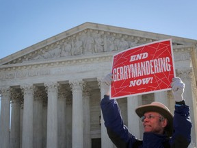 A demonstrator holds a sign during a Fair Maps rally outside the U.S. Supreme Court, in Washington, U.S., March 26, 2019.