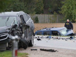 An OPP collision investigator examines the wreckages of two vehicles involved in a head-on crash on Manning Road in the Tecumseh area on Oct. 21, 2019.