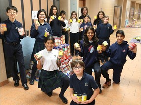 Students from Academie Ste Cecile International School in Windsor, display some of the 10,000 cans collected by 150 students during the annual can drive to benefit the Saint Vincent de Paul organization in this file photo from December 2016.