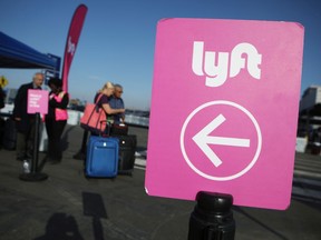 Arriving passengers wait to board Lyft vehicles at the new 'LAX-it' ride-hail passenger pickup lot at Los Angeles International Airport (LAX) on November 6, 2019 in Los Angeles, California. The airport has instituted a ban on Lyft, Uber and taxi curbside pickups as airport construction increases during a modernization program. Passengers have complained of long wait times and confusion at the pickup area, especially during peak hours. Passengers must depart their terminal and then ride a shuttle bus or walk to the separate pickup lot.