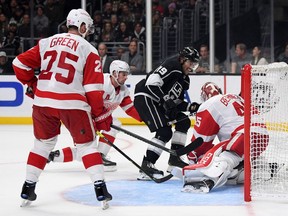 Alex Iafallo of the Los Angeles Kings scores a game winning goal between Jonathan Bernier, Dylan Larkin and Mike Green of the Detroit Red Wings during a 3-2 Kings overtime win at Staples Center on November 14, 2019 in Los Angeles, California.