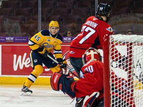 Erie Otters Drew Hunter (No. 45) looks to shoot on Windsor goalie Xavier Medina as Spitfires Matthew Maggio, left, and James Jodoin defend during Friday's OHL game at Erie Insurance Arena.