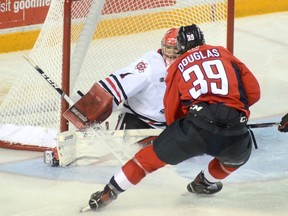 Niagara IceDogs' goaltender Tucker Tynan stops a shot from Windsor Spitfires' centre Curtis Douglas during Saturday's game in St. Catharines.