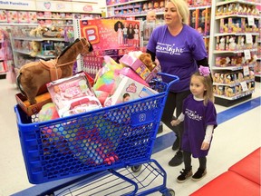 Zoe Dudzianiec, 4, and her mother Heidi Dudzianiec push a cart full of toys during a three-minute shopping spree at Toys "R" Us Canada in Windsor, Wednesday, Nov. 27, 2019.