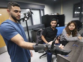 St. Clair College biomedical students Yacoub Abudalam, left, Abdullah Almahdi and Charmaine Lopez work on 3D printed hand project at the school on Thursday, November 21, 2019.