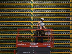 A technician inspects the backside of bitcoin mining at Bitfarms in Saint Hyacinthe, Quebec on March 19, 2018. Bitcoin is a cryptocurrency and worldwide payment system. It is the first decentralized digital currency, as the system works based on the blockchain technology without a central bank or single administrator.