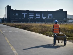 A worker walks on a road next to the new Tesla factory built in Shanghai on november 8, 2019.
