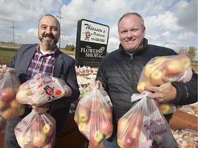 Derek Drouillard, left, executive director of the Windsor Essex Children's Aid Society, and Andrew Thiessen, owner of Thiessen's Orchards, pose for a photo with 15,000 lbs of apples Thiessen is donating to the Children's Aid Society, Tuesday, Nov. 5, 2019.