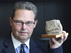 Thore Lederer, 57, poses with a piece of the Berlin Wall on Friday, November 8, 2019, at his LaSalle, ON. office. He was born in West Germany and grew up about 250 metres from the wall.