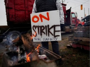 FILE PHOTO: A Teamsters Canada union worker pickets at the Canadian National Railway at the CN Rail Brampton Intermodal Terminal after both parties failed to resolve contract issues, in Brampton, Ontario, Canada November 19, 2019.