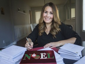 Stacey Robert-Tobin, a member of the Facebook group, Women of Windsor, fills out Christmas cards at her home, Thursday, Nov. 7, 2019.  The group is asking the public to mail them a blank Christmas cards with a stamp on the envelope so the group can hand out cards to people at the Downtown Mission and other local agencies over the holidays.