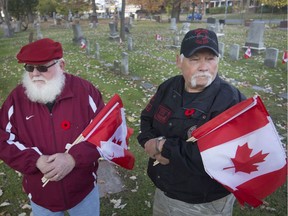 Windsor Veterans Memorial Services Committee president, Paul Lauzon, and vice-president, Karl Lovett, left, are pictured at Windsor Grove Cemetery, Tuesday, Nov. 5, 2019, where many Canadian flags went missing.