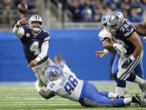 Dallas Cowboys quarterback Dak Prescott (4) passes the ball as Detroit Lions defensive end Mike Daniels (96) attempts to tackle him during the fourth quarter at Ford Field.