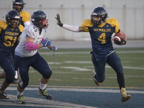 Kennedy's Lavon Fielder-Pierce rushes for a gain while being chased by Cardinal Carter's Noah Anscombe, left, in the WECSSAA football AA football final at Alumni Field on Monday.