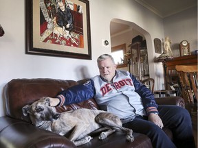 Windsor community member Joe McParland sits with his greyhound Tessie under a painting of his other greyhound Vici, who was fatally attacked by a pit bull earlier this year. Photographed Nov. 8, 2019.