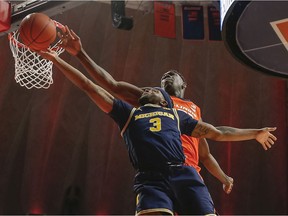 Zavier Simpson of the Michigan Wolverines has his shot blocked by Kofi Cockburn of the Illinois Fighting Illini during the second half at State Farm Center on December 11, 2019 in Champaign, Illinois.