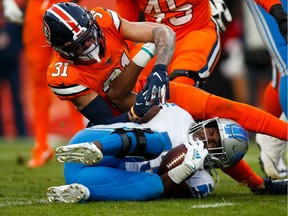 Safety Justin Simmons of the Denver Broncos applies a hard hit to running back Kerryon Johnson of the Detroit Lions during the third quarter at Empower Field at Mile High on Dec. 22, 2019 in Denver, Colorado. The Broncos defeated the Lions 27-17.