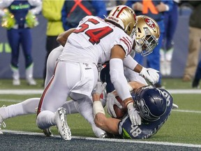 Tight end Jacob Hollister of the Seattle Seahawks is stopped just short of the goal line by linebacker Dre Greenlaw and linebacker Fred Warner of the San Francisco 49ers in the fourth quarter at CenturyLink Field on December 29, 2019 in Seattle, Washington.