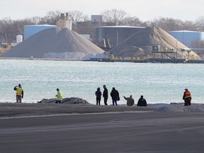 People survey the scene of a Detroit property contaminated with uranium and other dangerous chemicalsÊthat partially collapsed into the Detroit River on Friday, December 6, 2019.