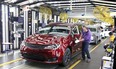 Inspector Frank Calzavara, front, with a Chrysler Pacifica Hybrid in velvet red in the Final Car area of FCA Windsor Assembly Plant, in a file photo from 2018.