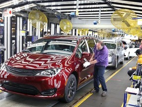 Inspector Frank Calzavara, front, with a Chrysler Pacifica Hybrid in velvet red in the Final Car area of FCA Windsor Assembly Plant, in a file photo from 2018.