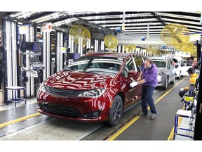 Windsor, Ontario. Dec. 7, 2018 --  Inspector Frank Calzavara, front, with a Chrysler Pacifica Hybrid in velvet red in the Final Car area of FCA Windsor Assembly Plant where generous donations to United Way Centraide Windsor Essex County and Sparky's Toy Drive were announced Friday December 7, 2018. FCA workers donated $1.2 million to United Way.