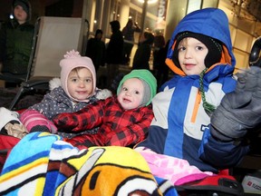 Ainsley DeVries, 4, left, and siblings Beckett, 1, and Greyson, 6, where waiting for Santa to arrive on Riverside Drive West near the Art Gallery of Windsor on Saturday.