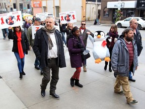 About two dozen area residents including Michael Brennan, left, of the AIDS Committee of Windsor, walk from Craft Heads Brewery to the University of Windsor's School of the Creative Arts during Rock the Ribbon event on World AIDS Day Sunday.
