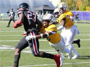 Windsor's Malcolm Thompson, seen a right making a tackle, has battled back from two ACL injuries to sign a contract with the CFL's Calgary Stampedes.