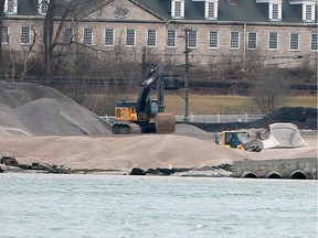 Heavy machinery move tons of crushed stone around the Detroit, Michigan shoreline at Detroit Bulk Storage, at the former Revere Copper and Brass site, on Dec. 4, 2019.  Historic Fort Wayne is shown behind.