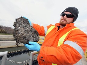Amherstburg sanitary sewage plant operator Kass Bowden holds a nearly solid clump of fats, grease and oil which collects and clogs the sewage treatment system, in this file photo from Dec. 23.