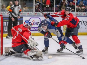 Windsor Spitfires' goalie Kari Piiroinen makes a stop on Saginaw Spirit forward Dalton Durham as Windsor's Jean-Luc Foudy applies pressure during Saturday's OHL game at the Dow Event Center.