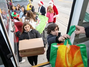 Students and faculty at Christ the King Catholic Elementary School carry gifts to Santa's School Bus on Friday, Dec. 13, 2019, after collecting the donations from their own school along with those from L.A. Desmarais, Notre Dame, St. Andrew, St. Gabriel and St. Joseph's High School. Santa will be making deliveries to local charities such as the Children's Aid Society and Advocating Young Minds.