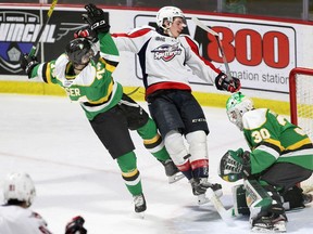 London Knights defenceman Ben Roger, left, checks Windsor Spitfires forward Matthew Maggio as Knights goaltender Brett Brochu concentrates on the rebound during Sunday's OHL game at the WFCU Centre.