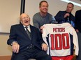 Tony Peters, left, smiles after receiving a team jersey from Windsor Spitfires coach Trevor Letowski and owner Brian Schwab, right, during a celebration Friday of his 100th birthday at Windsor Regional Hospital's Met Campus.