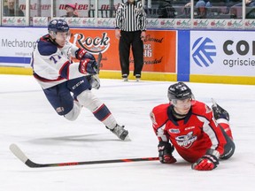 Windsor Spitfires Will Cuylle (13) blocks a shot by SaginawÕs Reilly Webb (77).        Eric Young, Saginaw Spirit